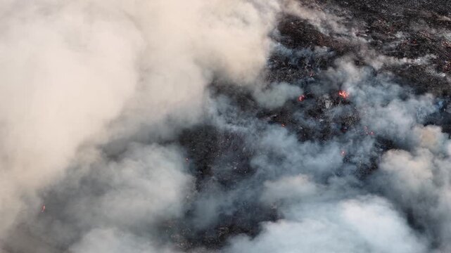 Aerial drone footage of burning landfill fire and smoke