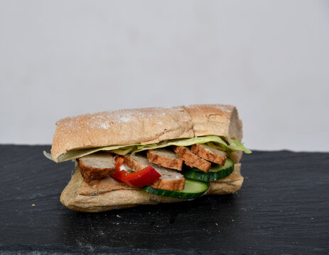 Frisch belegtes Sandwich mit Gem&uuml;se Bulette Fleisch &ndash; Snack to go, gesund, knuspriges Brot, Mittagessen, Takeaway, Foodfotografie, minimalistisch, Copyspace, isoliert