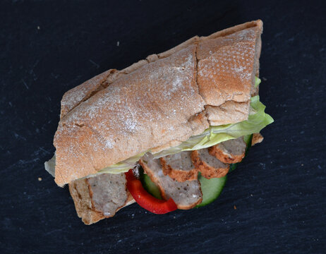 Frisch belegtes Sandwich mit Gem&uuml;se Bulette Fleisch &ndash; Snack to go, gesund, knuspriges Brot, Mittagessen, Takeaway, Foodfotografie, minimalistisch, Copyspace, isoliert