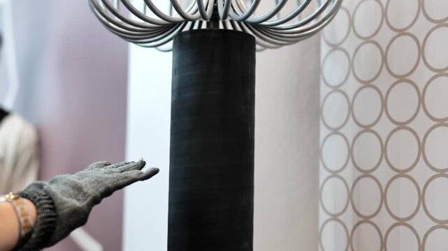 Hand wearing a metal glove receiving an electric spark from a Nikola Tesla coil