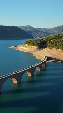 Aerial summer view of Serre-Poncon Lake with Chanteloube Bay and old abandoned railroad viaduct in Durance Valley. French Alps, Hautes-Alpes, France