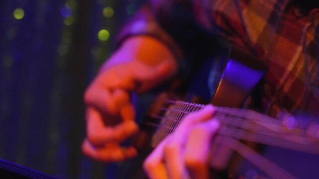 Close-Up of Musician Hands Playing Guitar Under Warm Stage Lighting