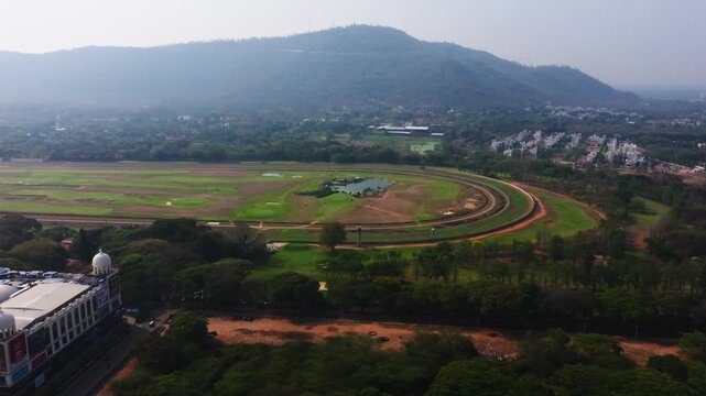 Mysore Race Course with Chamundi Hill and Mall Of Mysore at karnataka, india. day time, push back shot, drone shot, 4k.