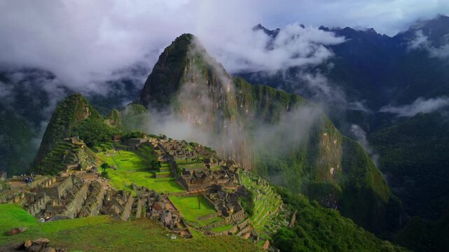 Peru's Machu Picchu World heritage site sanctuary Inca Temple early morning landscape low clouds fog layer Huayna Picchu Mountain Inca Trail Circuit Aguas Calientes Peruvian Andres Mountains zoom out