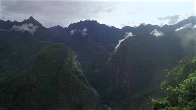 Machu Picchu Pueblo lookout Peruvian Andres highlands jungle Mountains Aguas Calientes Peru landscape early morning sunrise fog layer clouds Inca Trail Temple Vilcanota Urubamba River pan left