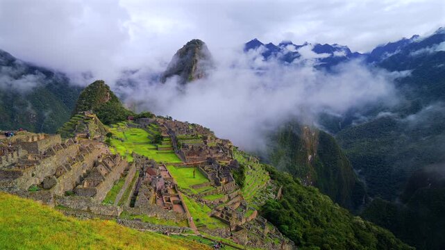 Peru's Machu Picchu landscape  Inca Trail Temple early morning low clouds fog layer Huayna Picchu Mountain Circuit World heritage site sanctuary Aguas Calientes Peruvian Andres Mountains pan left