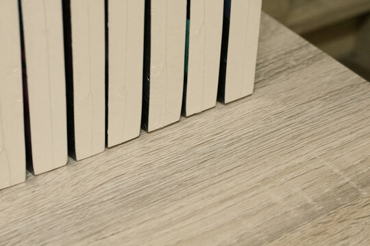 Close-Up of Beige Book Spines Wrapped in Clear Plastic, Minimal Library Book Collection Background