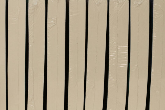 Close-Up of Beige Book Spines Wrapped in Clear Plastic, Minimal Library Book Collection Background