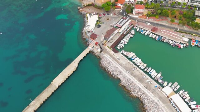 Alanya, Turkey. Kizilkule Red Tower in soft morning light with gentle Mediterranean waves at shoreline.. Aerial View, MasterShots, Fly Forward - Roll, Tilt up