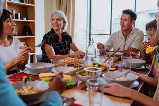 Family and friends reunion at home. Happy multigenerational family enjoying meal together at home