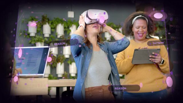 Woman putting on white VR headset, gesturing at purple UI, colleague tapping tablet for tech demo