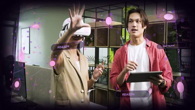 Woman wearing VR headset starting AR overlays by pointing in office, man adjusting tablet for demo