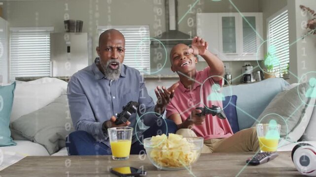 Father and son playing game, controller tap causing floating icons, both pointing to guide them