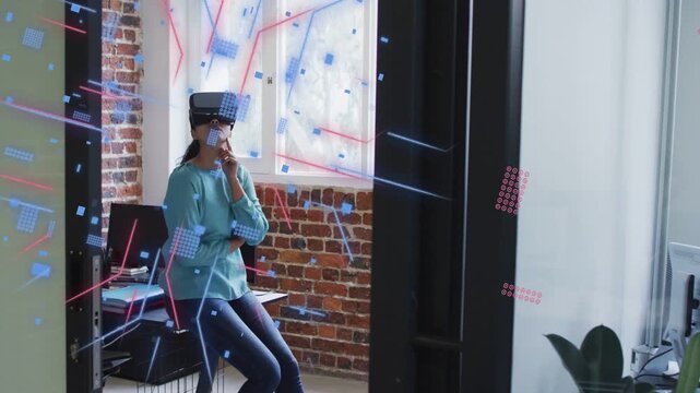 Animated graphics appearing, woman sitting wearing tethered VR, squares growing exploring tech data