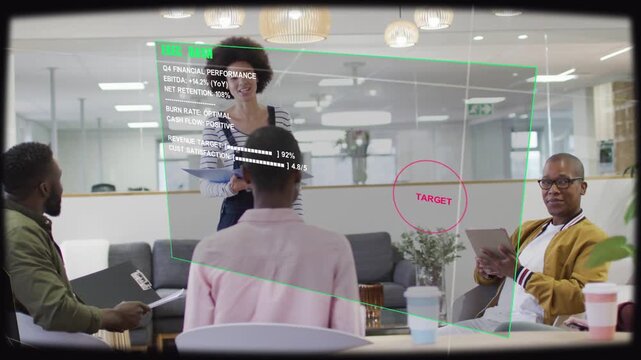 Presenter presenting and pointing in lounge, overlaying HUD marking TARGET, guiding business goals