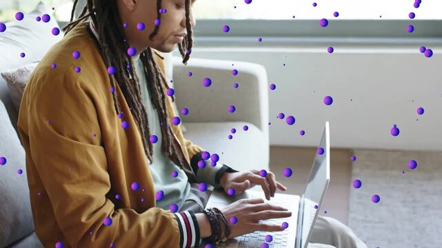 Worker starting typing on laptop, leaning, camera revealing face, purple dots overlaying for work