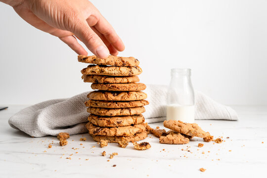 Hand reaching for stack of homemade chocolate chip cookies with