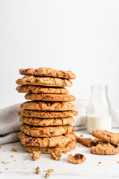 Stack of homemade chocolate chip cookies next to a vintage glass