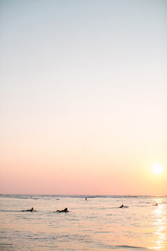Peaceful sunset surf session with surfers in the water