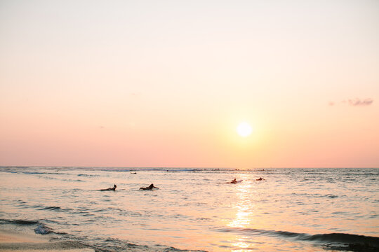 Scenic ocean landscape with surfers enjoying golden hour