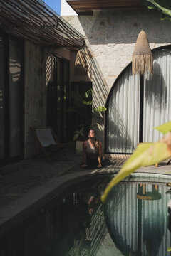 Serene woman practicing yoga by villa pool, Canggu, Bali
