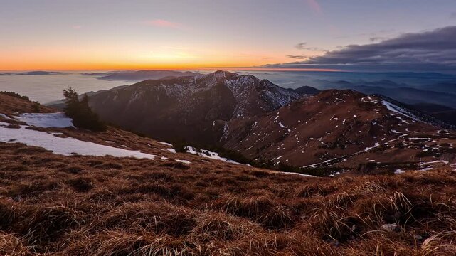 Wide-angle perspective of a high-altitude mountain landscape during the golden hour sunset