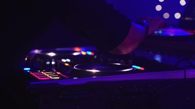 Hands mixing on DJ controller, colorful LED buttons glowing, closeup of technician wrist and fingers adjusting jog wheel, quick scratch moves, illuminated case and rack, pulsing bass and club energy