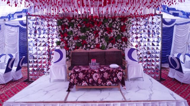 Traditional wedding stage decoration with floral backdrop and seating