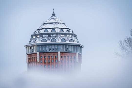 Old water tower in Hamburg covered in snow and surrounded by fog
