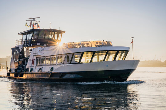 Passenger ferryboat sailing in Hamburg harbour at sunrise