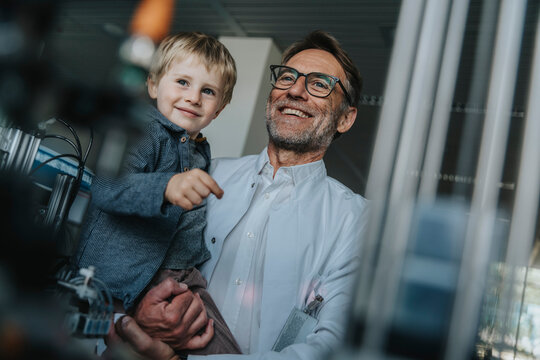 Scientist and child smiling together in laboratory with equipment