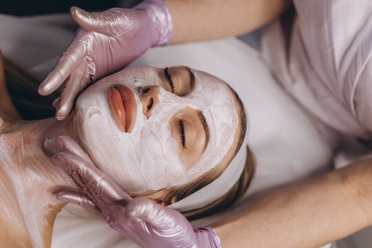 Beautician applying a facial mask during a spa treatment