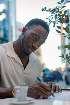 Businessman writing notes and working at an outdoor cafe