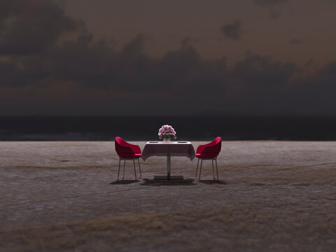 Romantic dinner table setup on an empty dark beach at night
