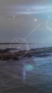 Vertical video: Horizon glow sparking HUD over shore dots forming rings growing beam marking coast