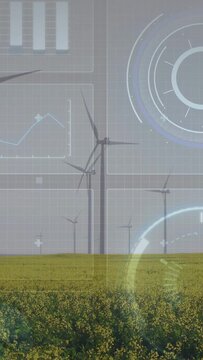 Vertical video: Wind turbines rotating by wind, HUD updating for power data over canola field