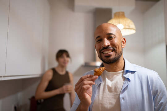 Couple laughing and enjoying a snack in the kitchen