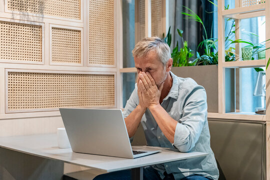 Business businessman feeling desperate at laptop in modern office