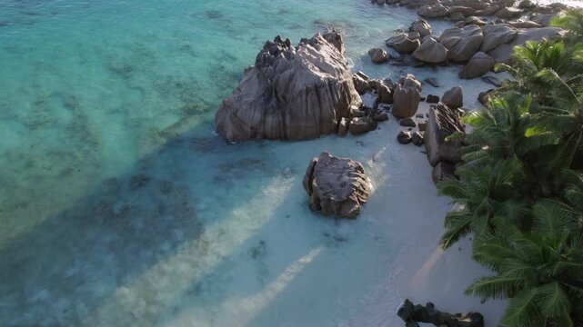 Drone of beautiful rocks near the shoreline of Anse Patates, passing ray fishes, La Digue, Seychelles 018, 30 fps