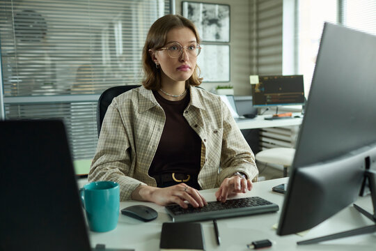 Focused developer typing code on computer in office