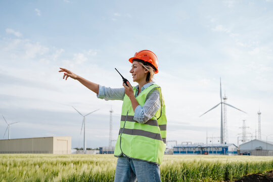 Engineer wearing reflective jacket and giving instruction at field