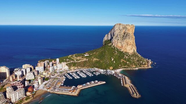 Aerial view of Calpe Spain featuring the iconic Penon de Ifach rock formation rising above the Mediterranean Sea with marina and coastal cityscape