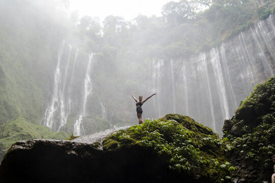 Woman exploring Tumpak Sewu Waterfall in the jungle of Java