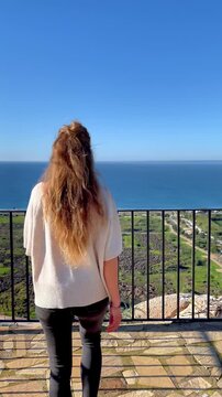 Woman looking at the sea from a terrace at sunset, costa tropical in Spain