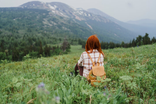 Tourist sitting on a mountainside enjoying landscape at Sheregesh
