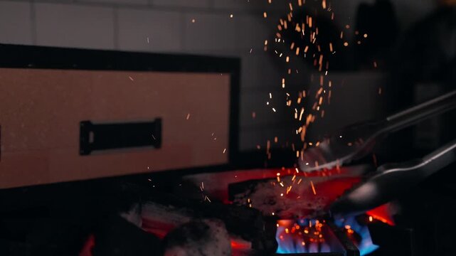 Embers dance off binchotan charcoal as they are heated and prepped for a konro grill (slow motion, 4K).