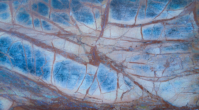 An abstract, defocused blue background in subdued light with a texture reminiscent of natural stone.