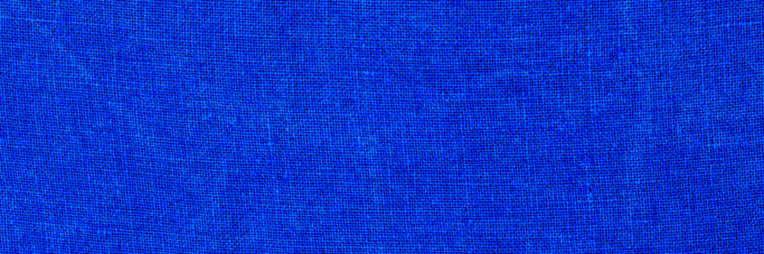 Bright blue fabric texture featuring smooth and even surface with visible weave patterns and threads