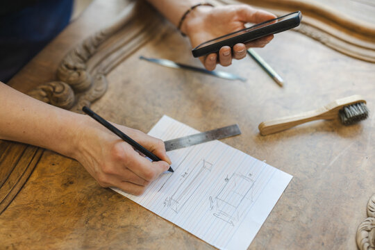 Sketching Furniture Design on Paper in Workshop

