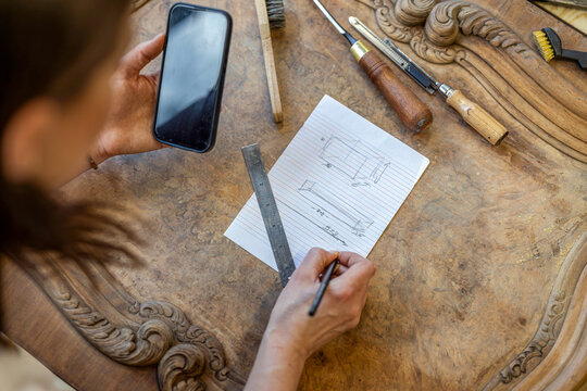 Sketching Furniture Design on Paper in Workshop
